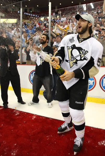 Kris Letang on ice with champagne.